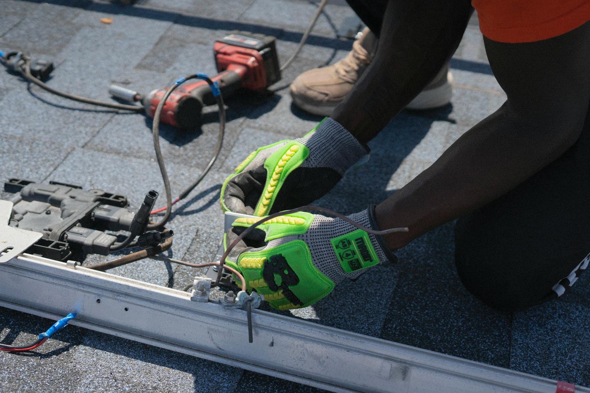 A roofing professional inspecting shingles on a steep-pitch residential roof in Draper, Utah