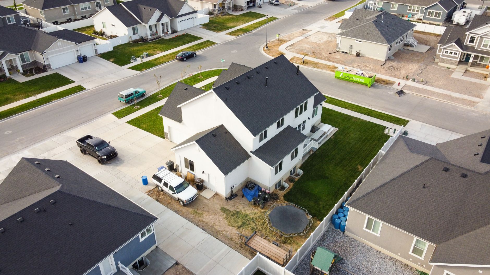 A professional roofer wearing safety gear inspecting an asphalt shingle roof on a West Valley City home.